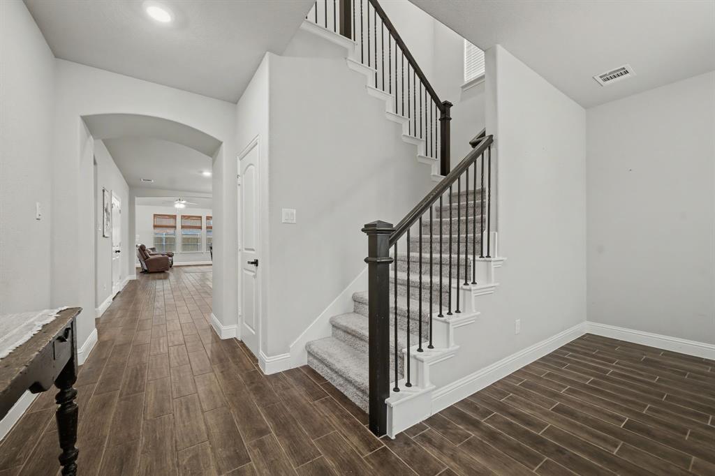 433 Forestridge Drive Fate, TX 75087 - Photo 3 of 38 a view of a hallway with wooden floor and staircase
