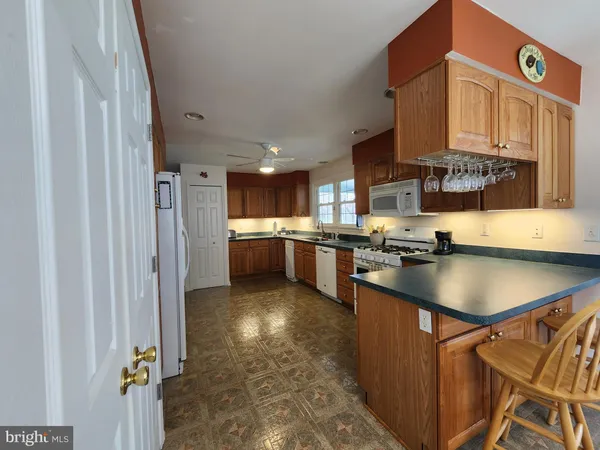 a kitchen with granite countertop a sink appliances cabinets and a counter top space