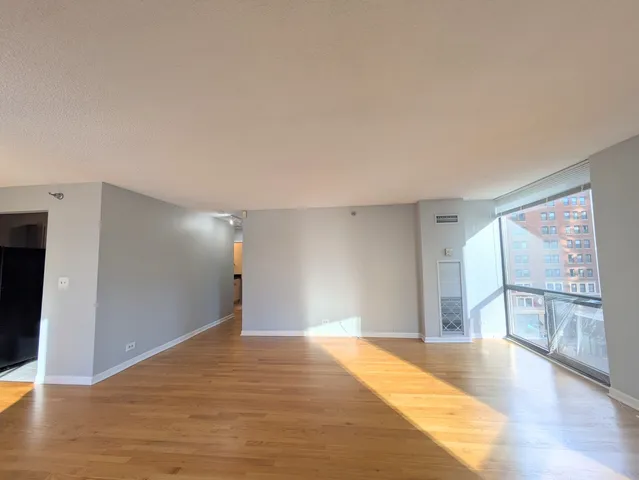 a view of empty room with wooden floor and fireplace