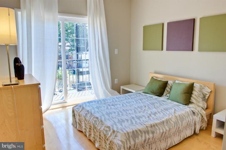 1917 2nd Street Northeast, Unit 201 Washington, DC 20002 - Photo 8 of 23 a bedroom with a bed and wooden floor