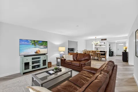 a living room with furniture a couch and kitchen view