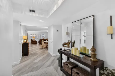 a view of a dining room and livingroom with furniture wooden floor a chandelier