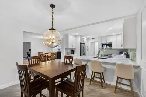 a view of a dining room with furniture and chandelier