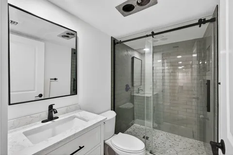a bathroom with a sink a toilet and shower