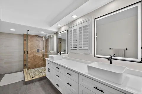 a bathroom with double sink and a mirror