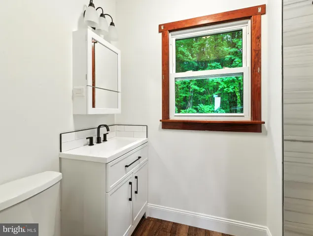 a bathroom with a sink a toilet and a window