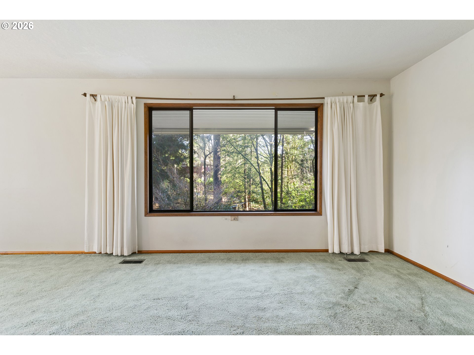10410 Southwest 25th Avenue Portland, OR 97219 - Photo 24 of 39 a view of an empty room with wooden floor and a window
