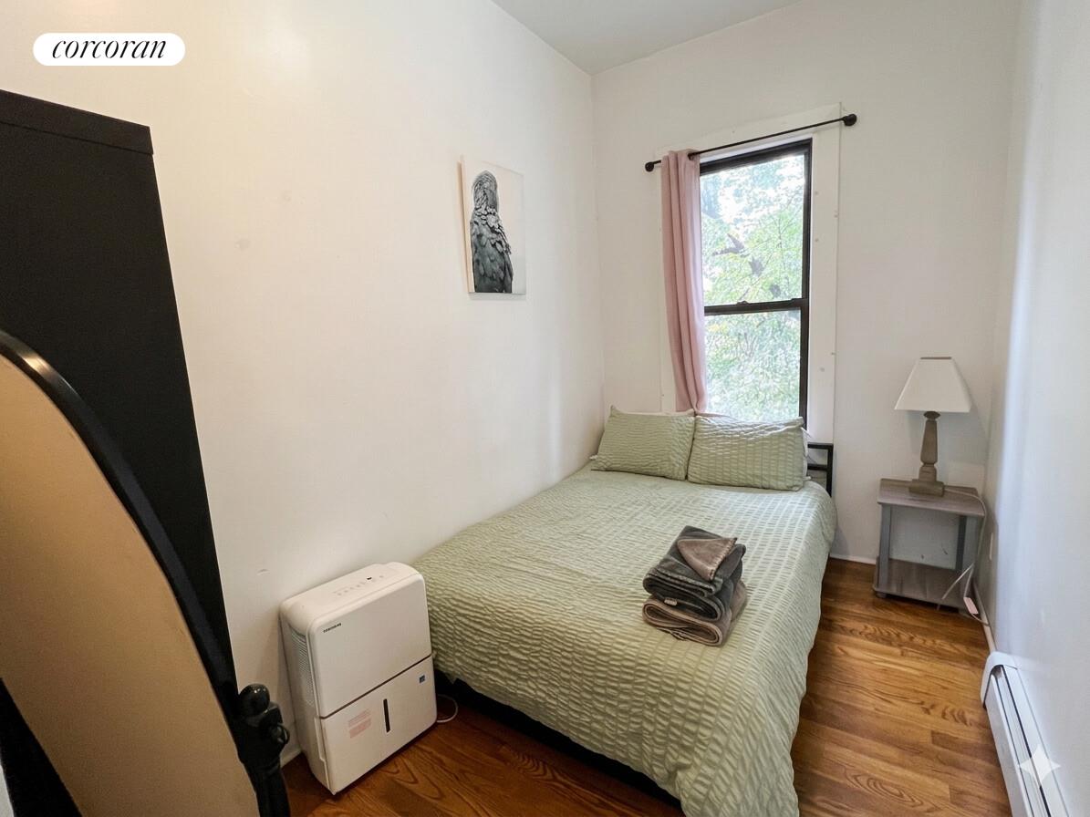 487 Hart Street Brooklyn, NY 11221 - Photo 10 of 19 a bed sitting in a bedroom next to a window