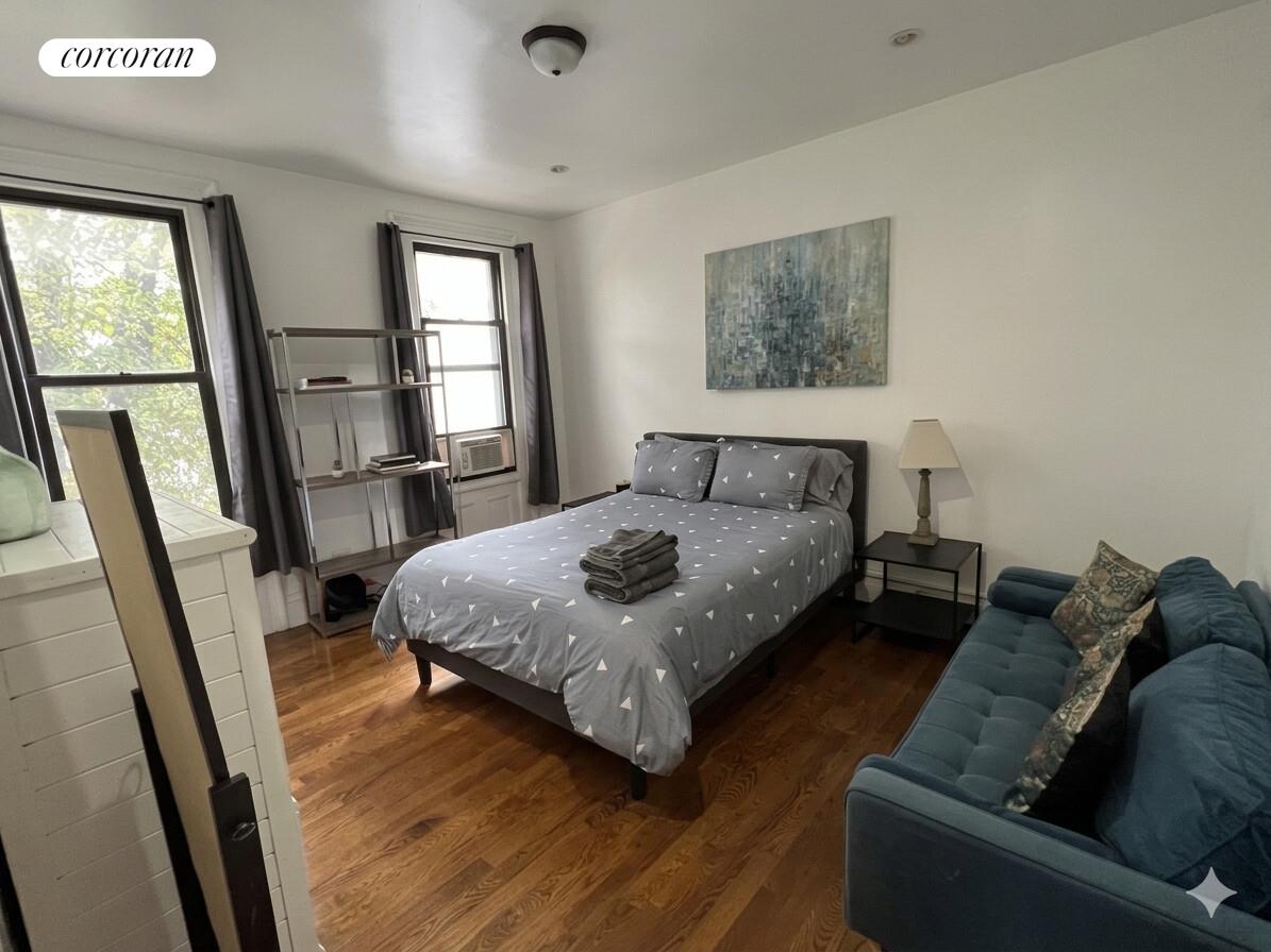 487 Hart Street Brooklyn, NY 11221 - Photo 11 of 19 a bedroom with a bed window and a couch