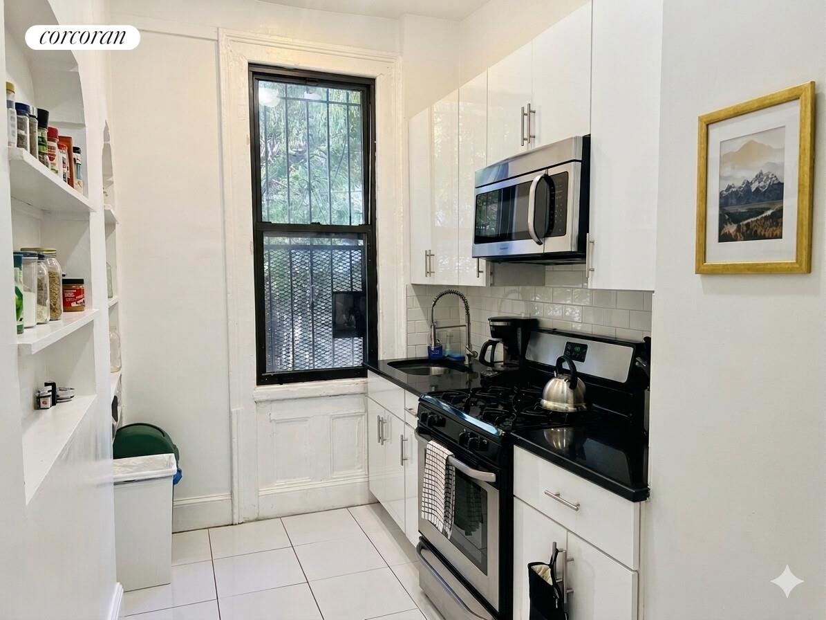 487 Hart Street Brooklyn, NY 11221 - Photo 4 of 19 a kitchen with stainless steel appliances granite countertop a stove and a microwave