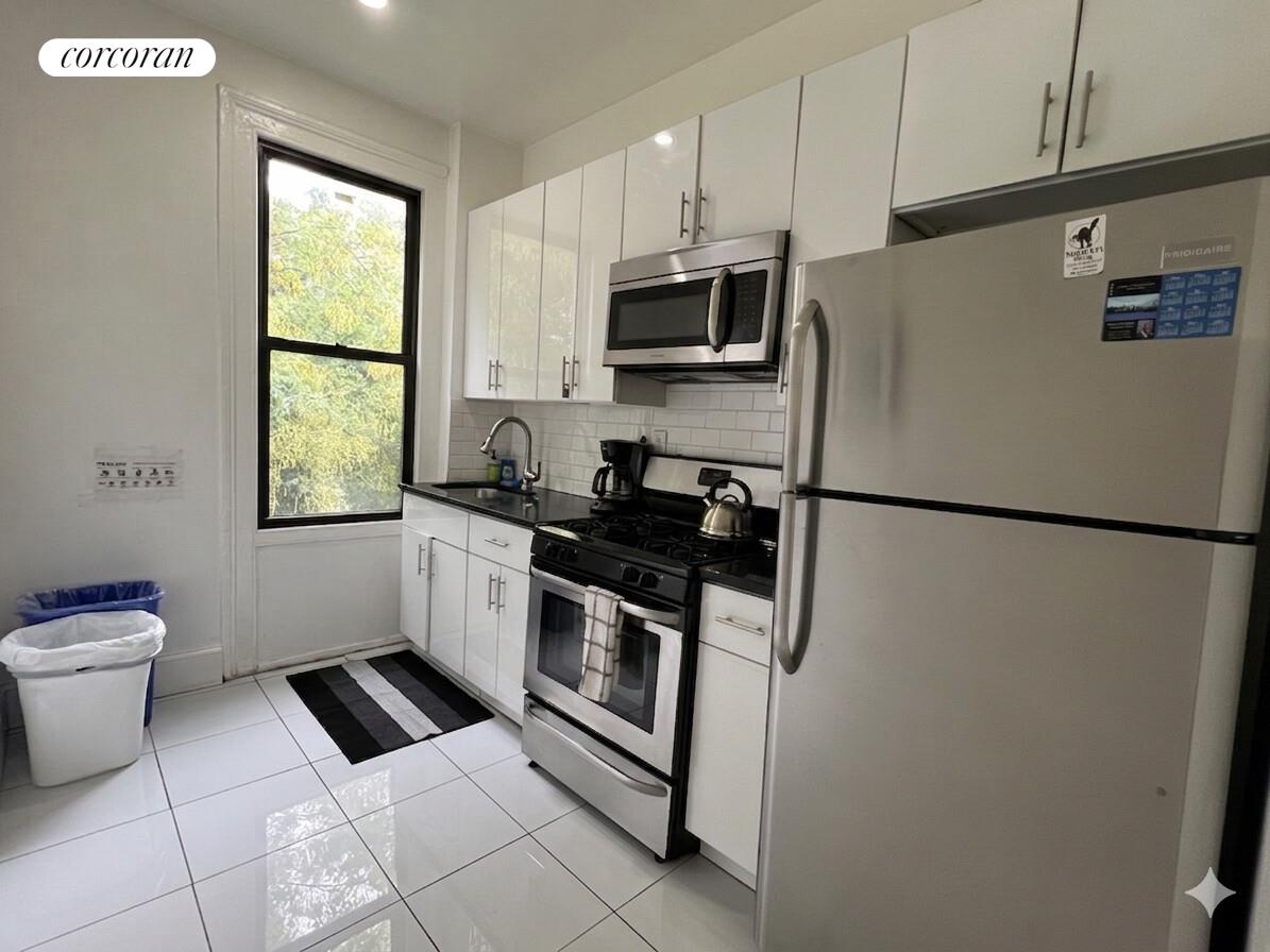 487 Hart Street Brooklyn, NY 11221 - Photo 9 of 19 a kitchen with stainless steel appliances a refrigerator sink and microwave