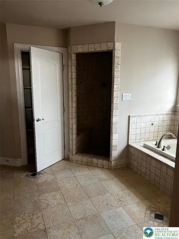 a spacious bathroom with a granite countertop double vanity and a mirror