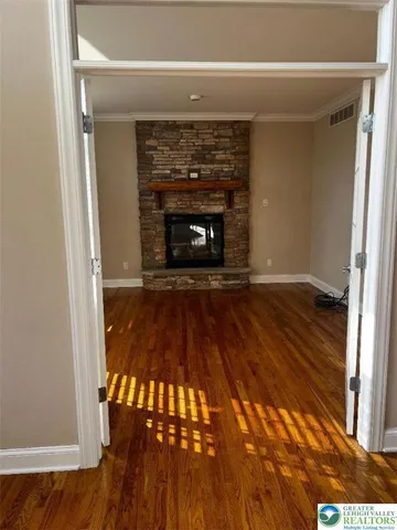 a view of a livingroom with wooden floor and a fireplace
