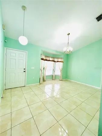 an empty room with a fan & a fan