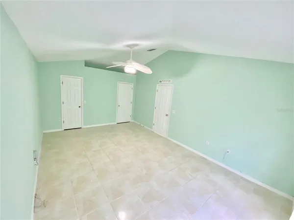 an empty room with a fan & a fan