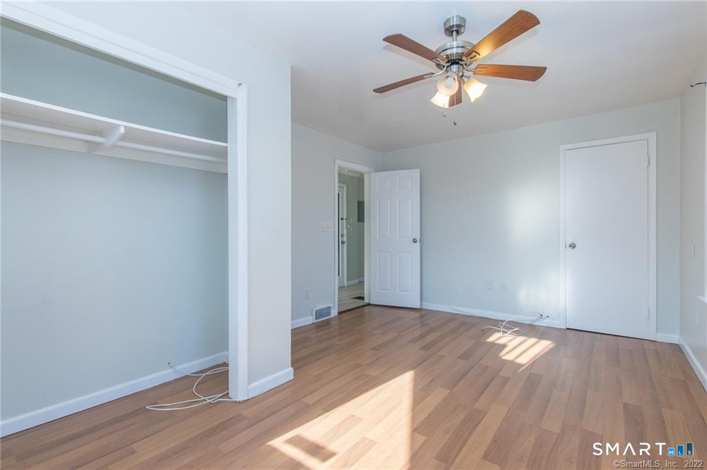 18 Lawrence Street Norwalk, CT 06854 - Photo 21 of 31 an empty room with wooden floor and a ceiling fan
