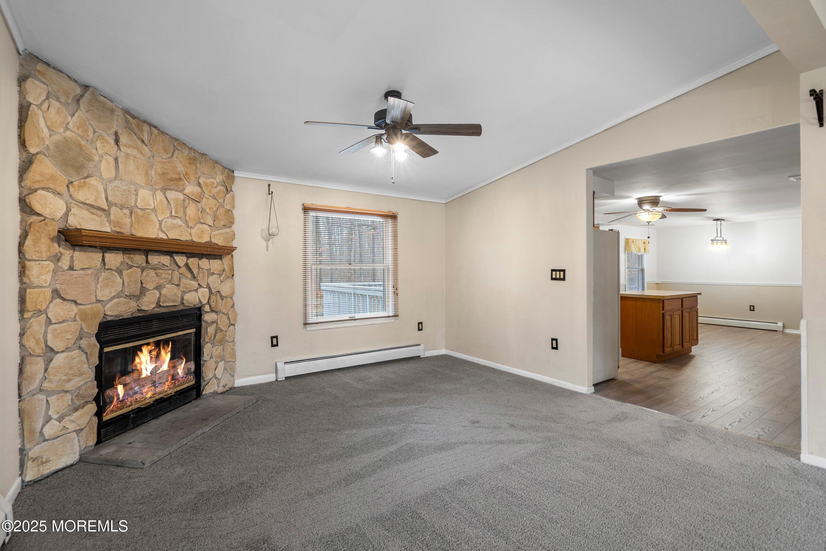 581 Sergey Road Jackson, NJ 08527 - Photo 5 of 38 a view of a livingroom with a fireplace a ceiling fan and windows