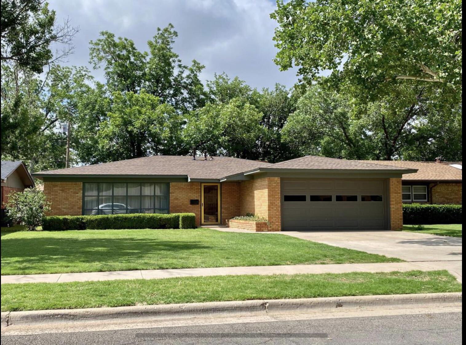 a front view of a house with a garden