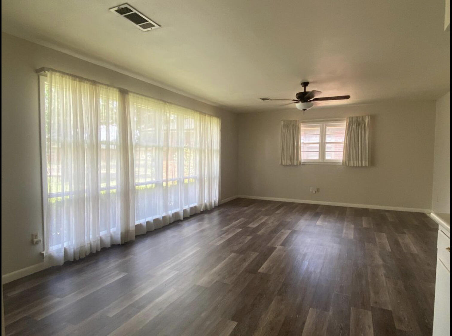 3505 46th Street Lubbock, TX 79413 - Photo 4 of 9 a view of an empty room with wooden floor and a window
