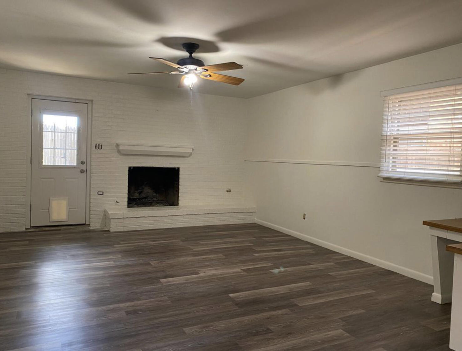 3505 46th Street Lubbock, TX 79413 - Photo 6 of 9 an empty room with wooden floor fireplace and windows