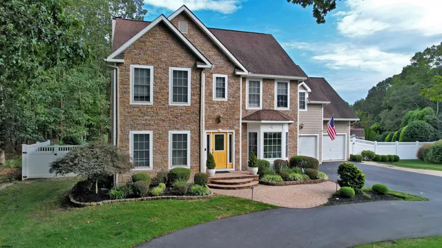 a front view of a house with a yard and outdoor seating