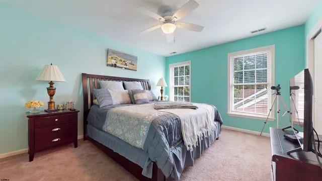 a view of a white house with a big yard and potted plants