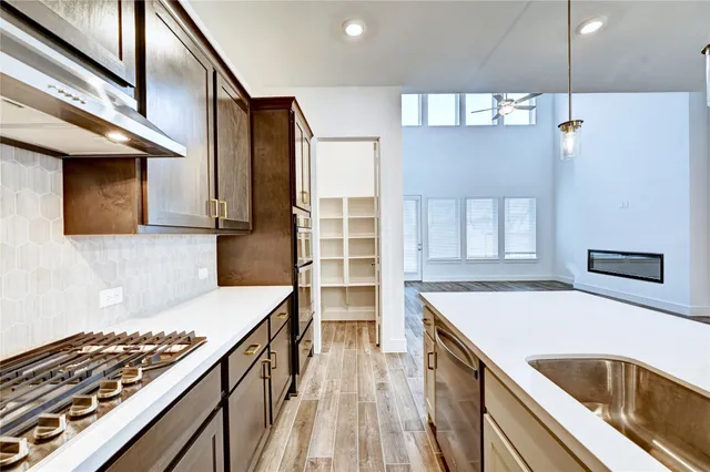 a kitchen that has a sink stove and cabinets
