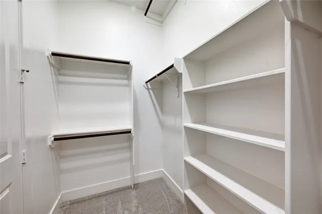 a view of walk in closet with empty racks