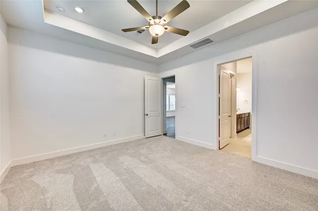 an empty room with closet and a ceiling fan