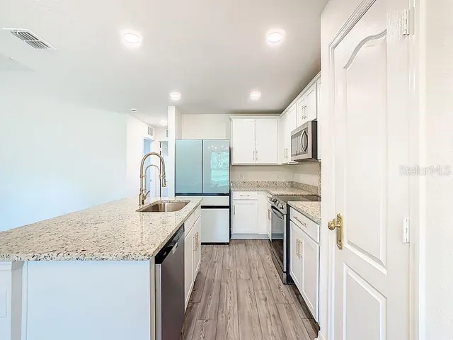 a kitchen with a sink a stove a refrigerator and cabinets