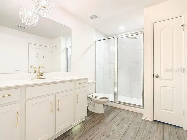 a bathroom with a sink a toilet and shower