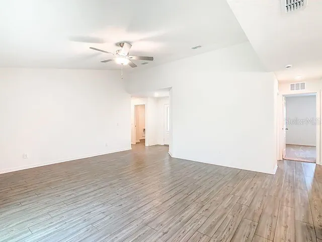 a view of an empty room with wooden floor