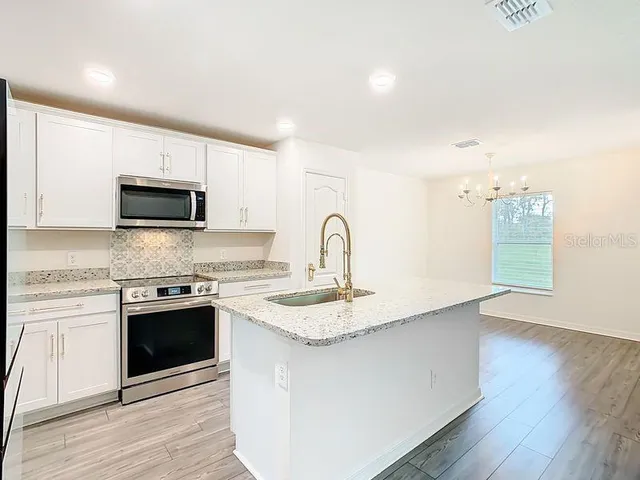 a kitchen with granite countertop a stove and a sink