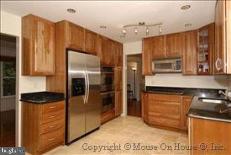 1826 Post Oak Trail Reston, VA 20191 - Photo 6 of 28 a kitchen with stainless steel appliances granite countertop a refrigerator and a stove