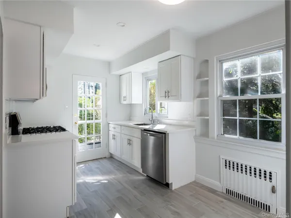a kitchen with a stove a sink and a window