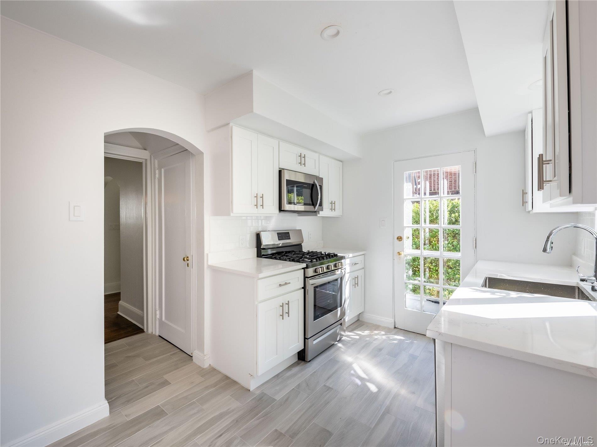 109 Chase Road Manhasset, NY 11030 - Photo 14 of 28 a kitchen with a stove a sink and a window
