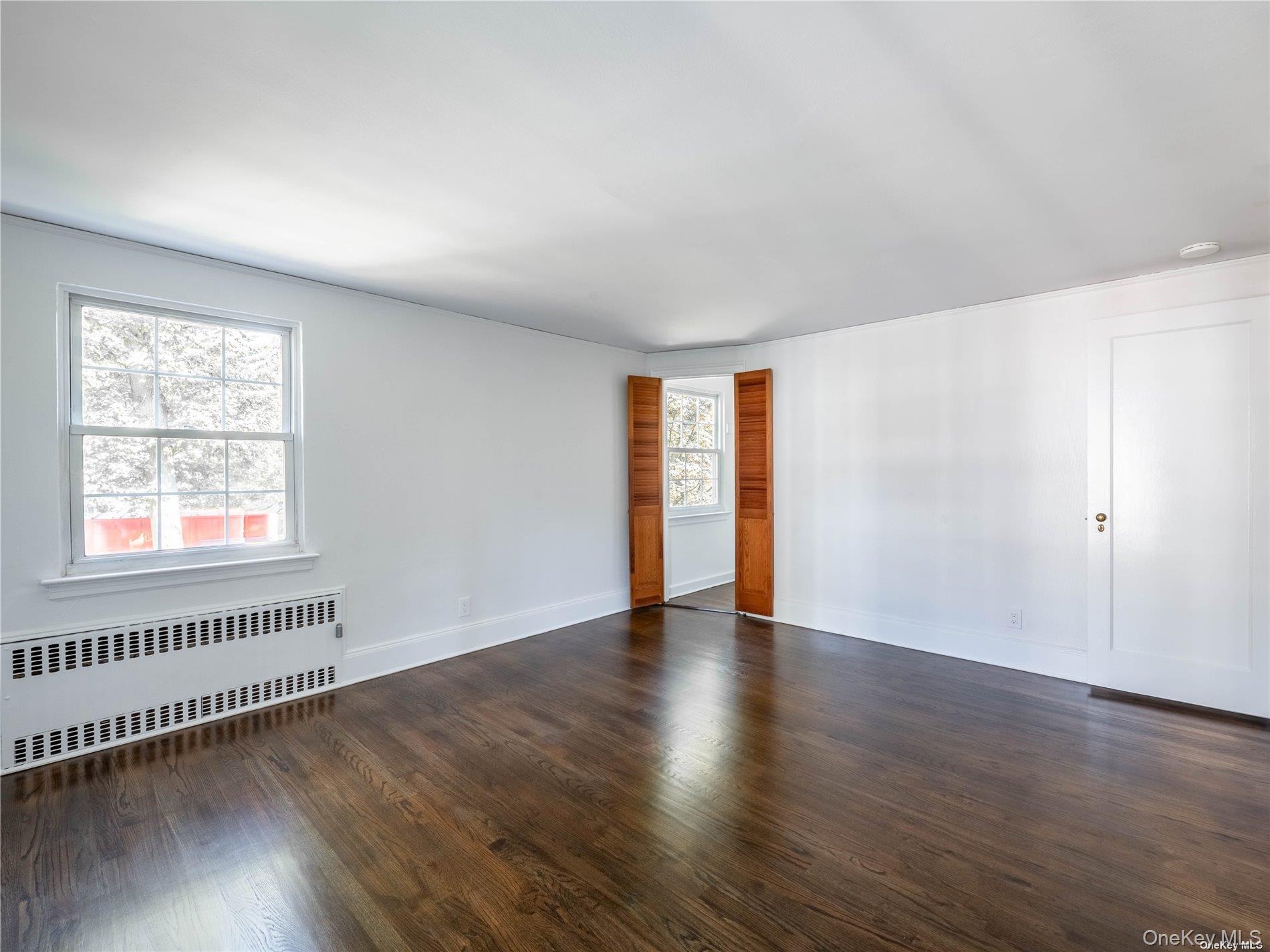109 Chase Road Manhasset, NY 11030 - Photo 22 of 28 an empty room with wooden floor and windows