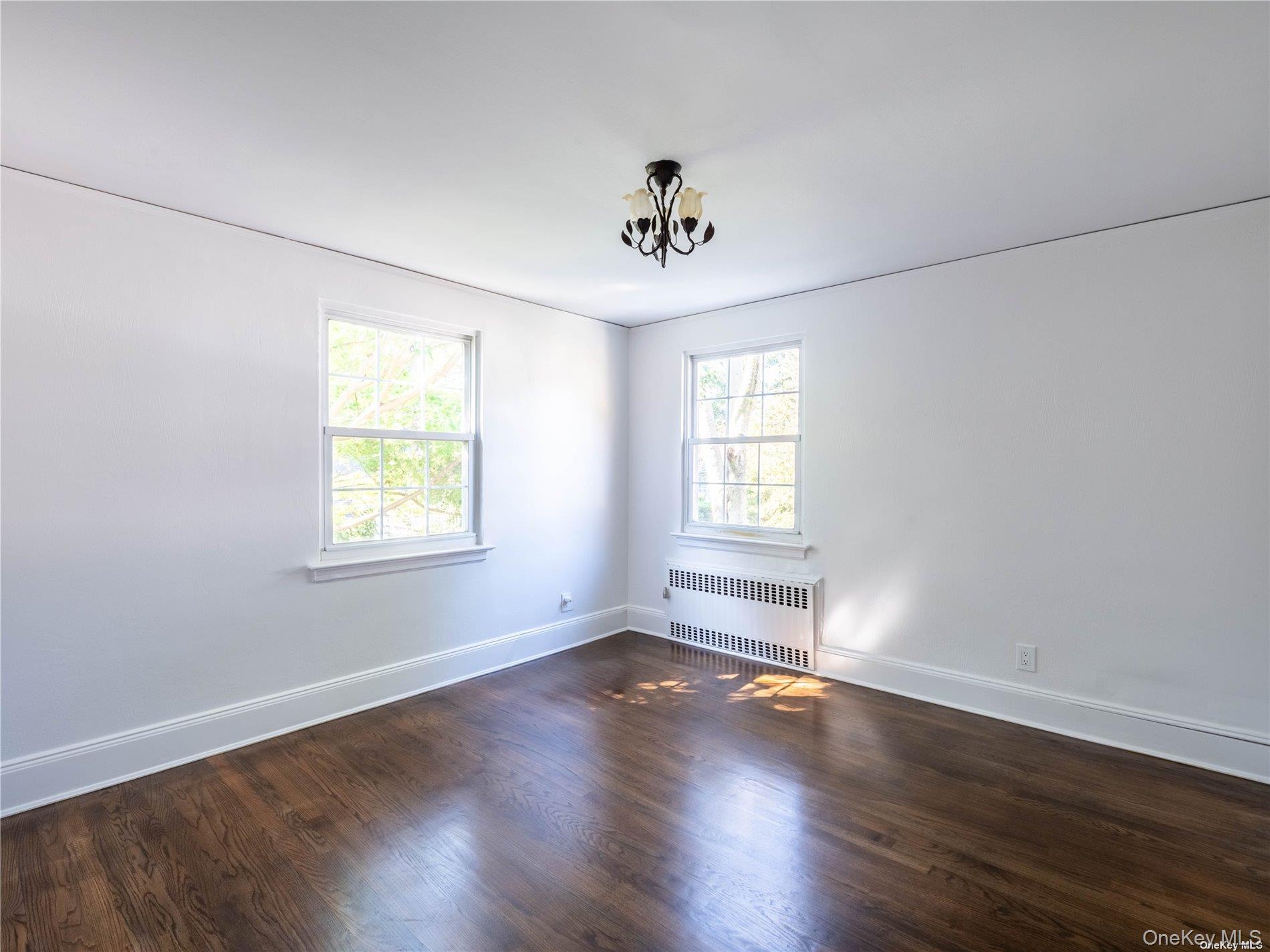 109 Chase Road Manhasset, NY 11030 - Photo 24 of 28 an empty room with wooden floor and windows