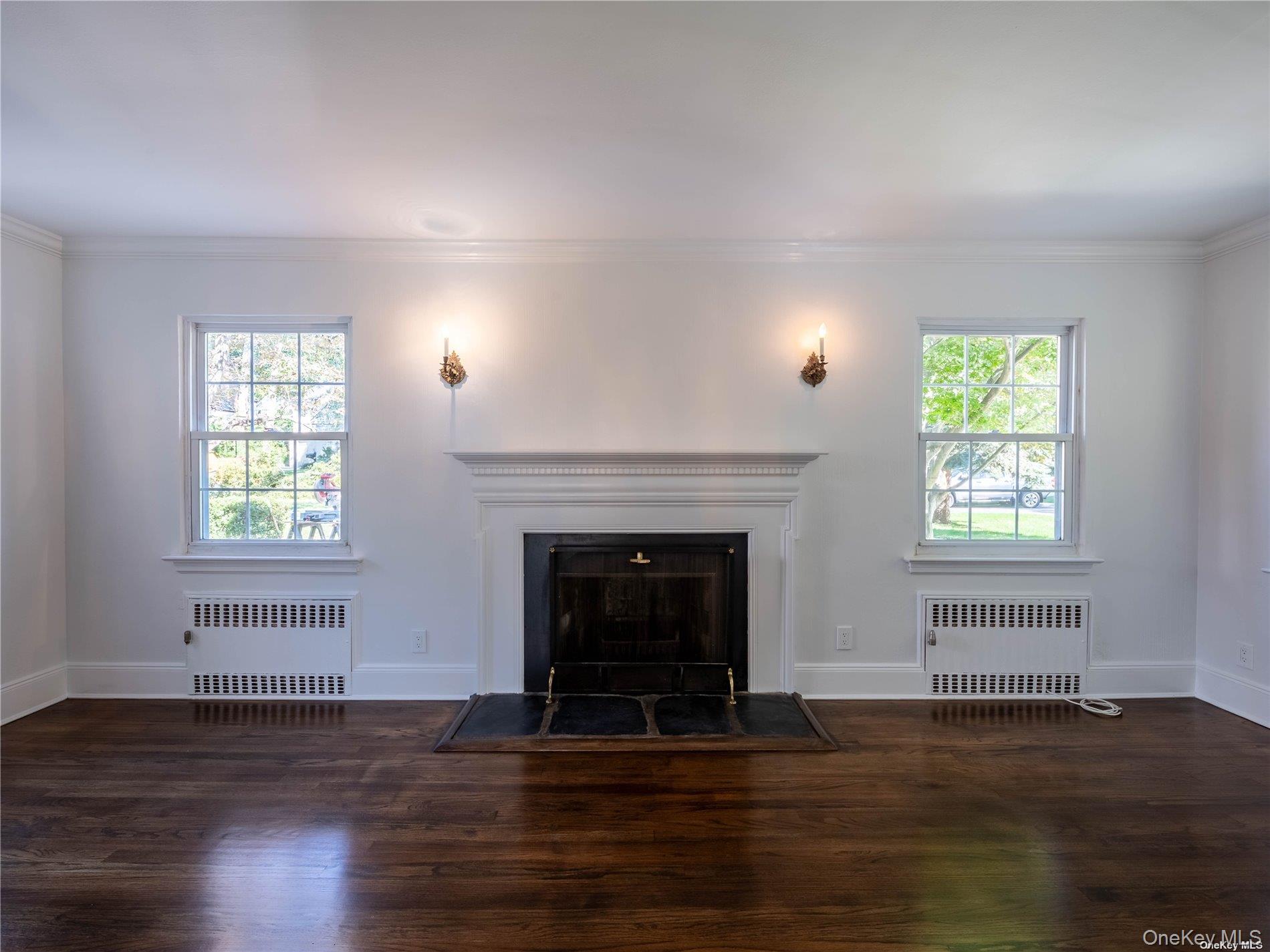 109 Chase Road Manhasset, NY 11030 - Photo 8 of 28 an empty room with wooden floor fireplace and windows