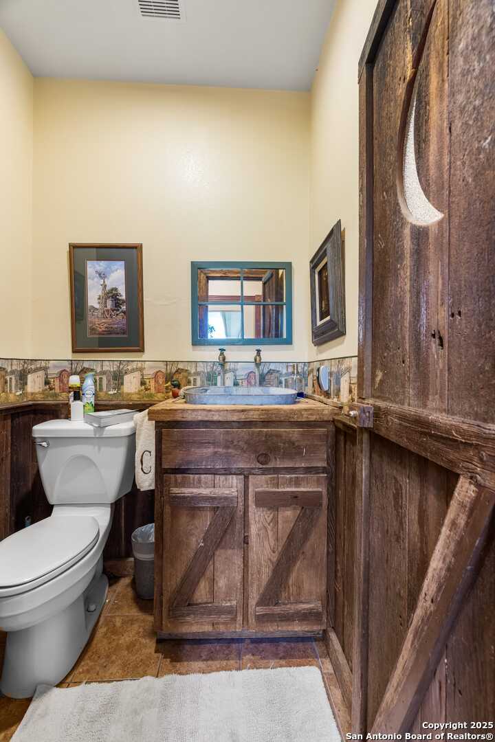 247 Huntleigh Road South Ingram, TX 78025 - Photo 13 of 41 a spacious bathroom with a granite countertop toilet sink and mirror