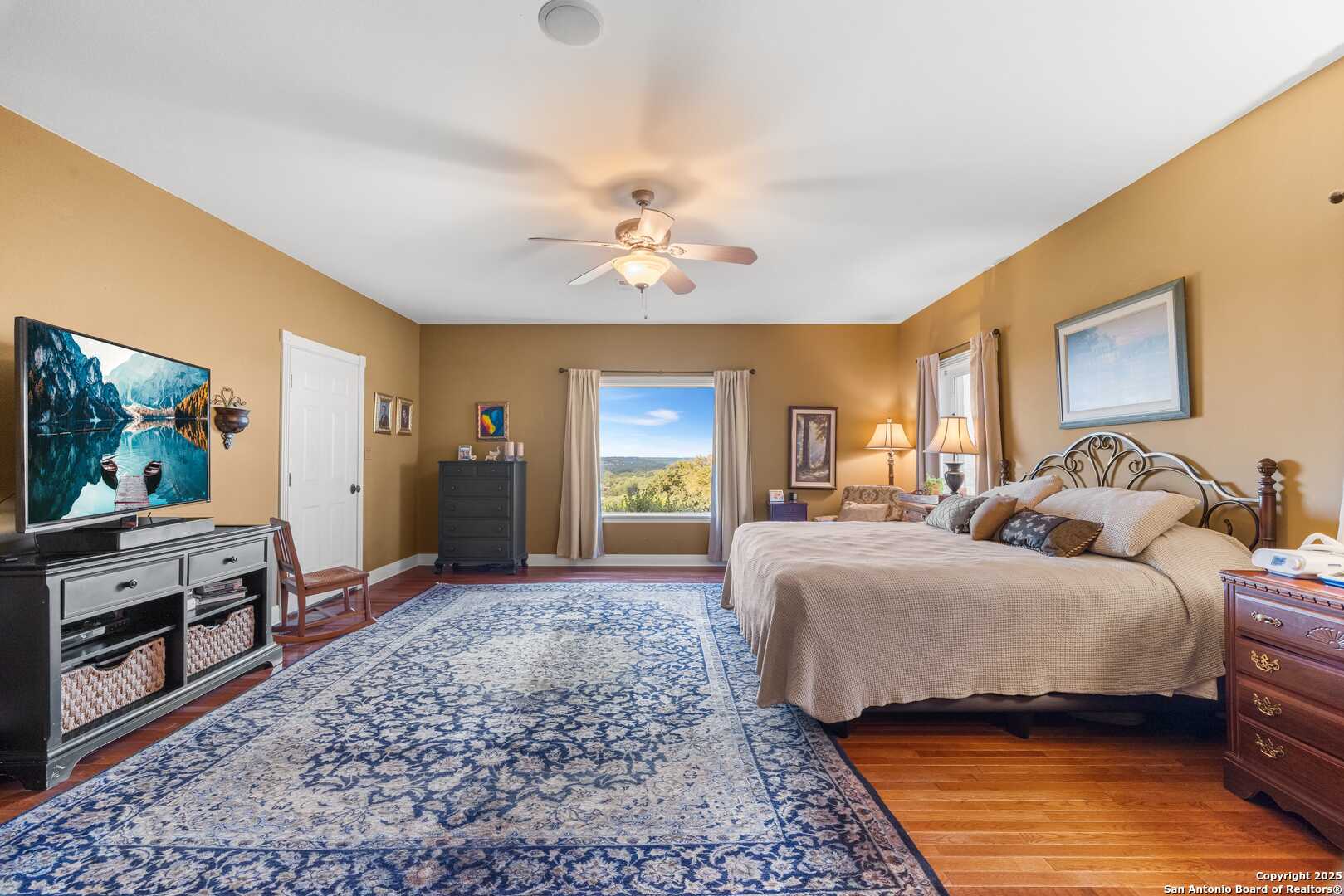 247 Huntleigh Road South Ingram, TX 78025 - Photo 25 of 41 a spacious bedroom with a bed and a flat screen tv