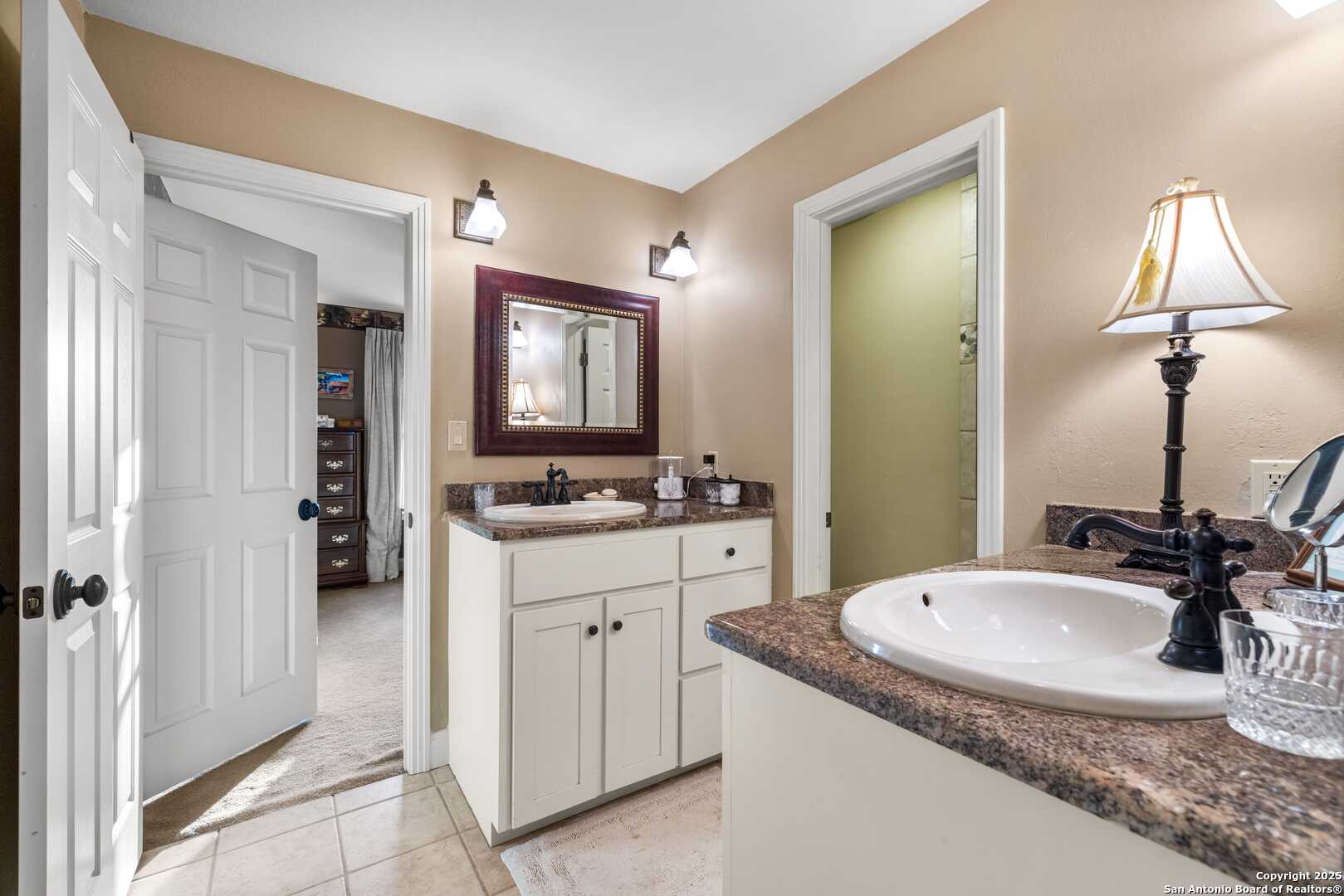247 Huntleigh Road South Ingram, TX 78025 - Photo 36 of 41 a bathroom with a granite countertop sink and a mirror