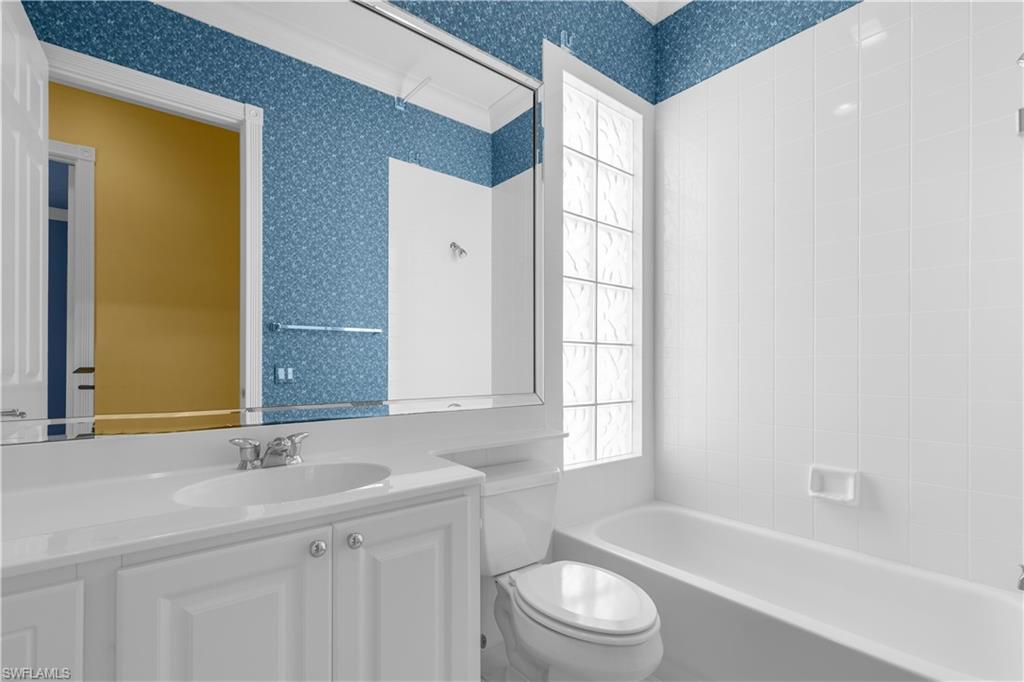 3790 Whidbey Way Naples, FL 34119 - Photo 29 of 49 a bathroom with a sink a toilet and tub