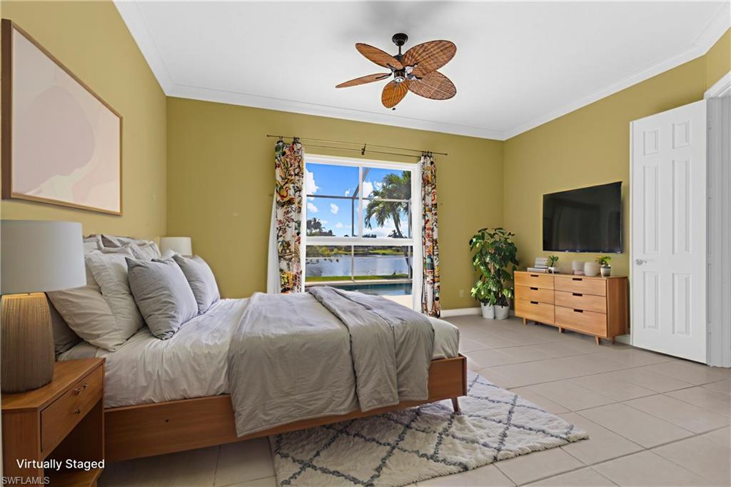 3790 Whidbey Way Naples, FL 34119 - Photo 35 of 49 a bedroom with a bed a flat screen tv and a chandelier
