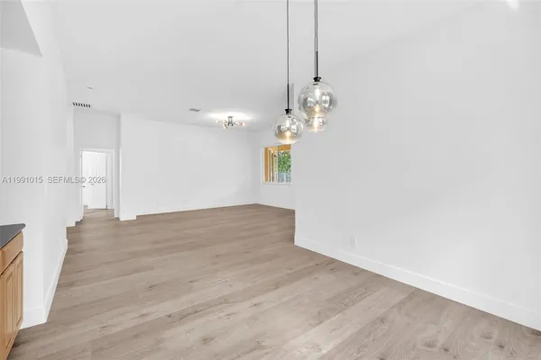 a view of a room with wooden floor and chandelier
