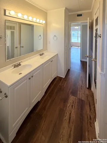 a spacious bathroom with a double vanity sink and mirror
