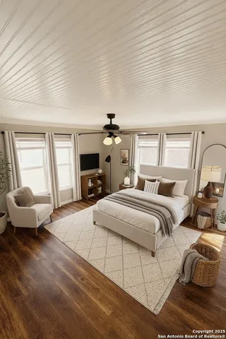 a spacious bedroom with a bed and wooden floor