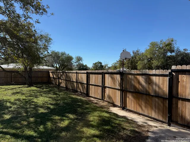 a view of a big yard with wooden fence