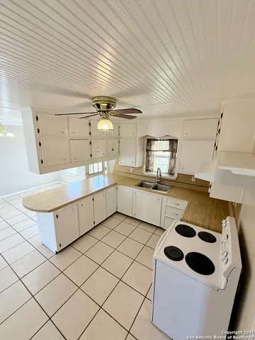 a kitchen with a sink a stove and cabinets