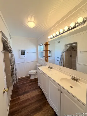 a spacious bathroom with a double vanity sink toilet and shower